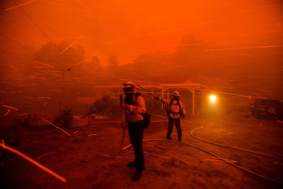 Firefighters work in the smoke and haze and embers from the Lake Hughes fire in Angeles National Forest on Wednesday, Aug. 12, 2020, north of Santa Clarita, Calif. (AP Photo/Ringo H.W. Chiu)