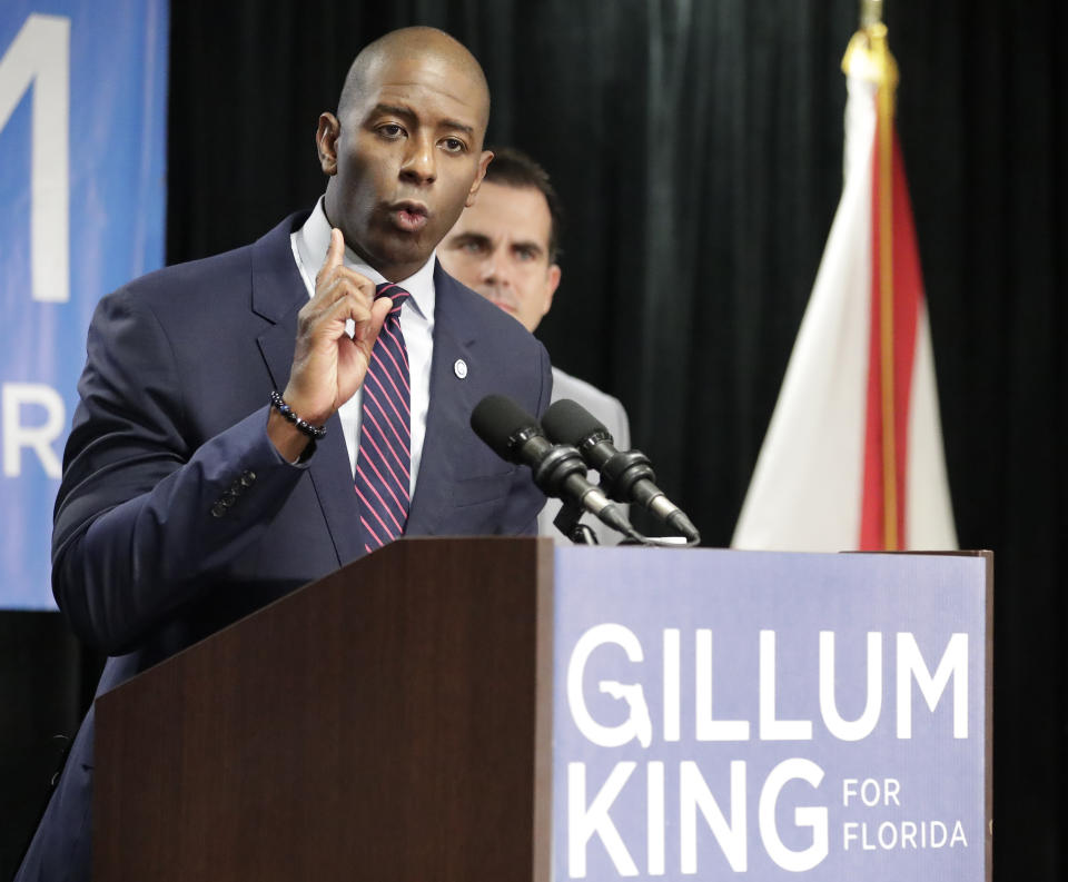 Florida Democratic gubernatorial candidate Andrew Gillum, left, speaks to supporters after he was endorsed by Puerto Rico Governor Ricardo Rossello, standing back right, during a campaign rally Monday Oct. 1, 2018, in Kissimmee, Fla. (AP Photo/John Raoux)