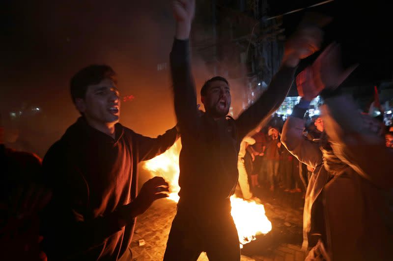 Palestinian demonstrators react as tires burn during a protest against the U.S. President Donald Trump's Mideast peace plan, in the northern Gaza Strip