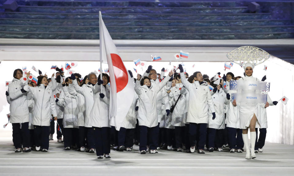 Ayumi Ogasawara of Japan carries the national flag as she leads the team during the opening ceremony of the 2014 Winter Olympics in Sochi, Russia, Friday, Feb. 7, 2014. (AP Photo/Mark Humphrey)