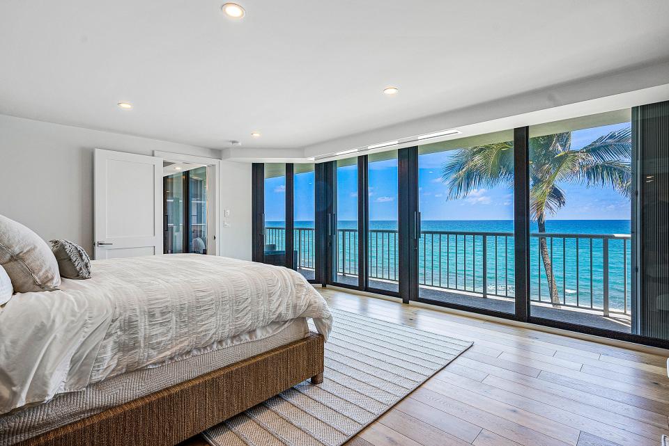 Sliding doors in the primary bedroom open onto the oceanview terrace. Floors throughout are covered in imported white oak planks.