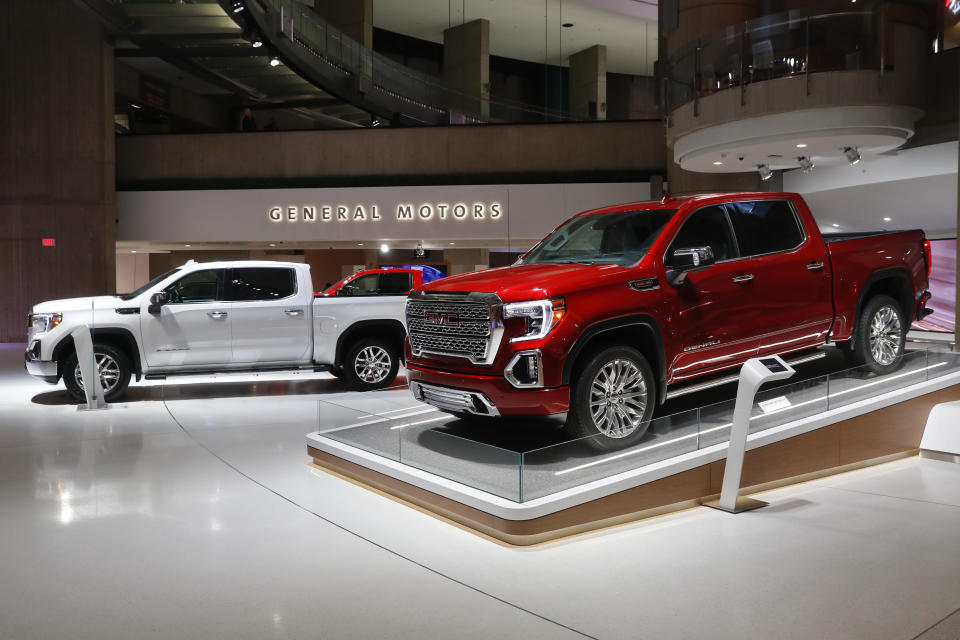 FILE- This Jan. 16, 2019, file photo shows a GMC Sierra pickup, left, and Denali in Detroit.  General Motors' posted an $8.1 billion net profit last year as it got better prices for vehicles sold in the U.S., its most lucrative market. The performance was far better than the previous year, when the company lost $3.9 billion due to a giant tax accounting charge.(AP Photo/Paul Sancya, File)