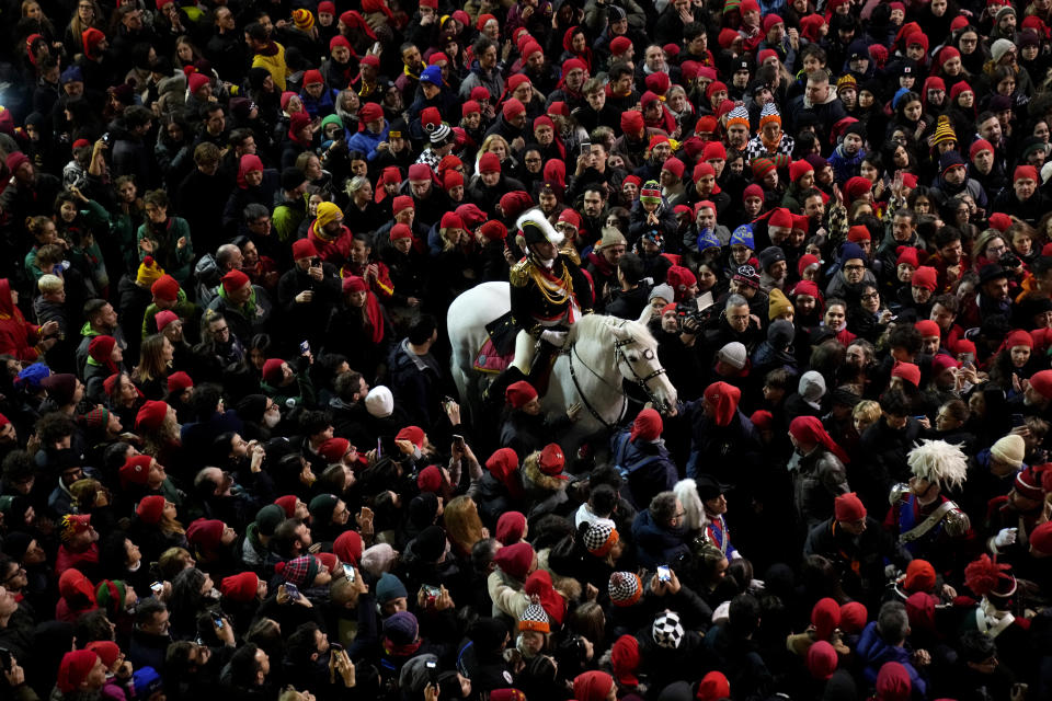 People look a man wearing a costume of Generale "General" at the end of the 'Battle of the Oranges" where people pelt each other with oranges as part of Carnival celebrations in the northern Italian Piedmont town of Ivrea, Italy, Tuesday, Feb. 13, 2024. (AP Photo/Antonio Calanni)