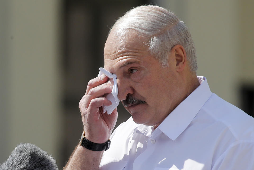Belarusian President Alexander Lukashenko wipes his face as he addresses his supporters gathered at Independent Square of Minsk, Belarus, Sunday, Aug. 16, 2020. Thousands of people have gathered in a square near Belarus' main government building for a rally to support President Alexander Lukashenko, while opposition supporters whose protests have convulsed the country for a week aim to hold a major march in the capital. (AP Photo/Dmitri Lovetsky)