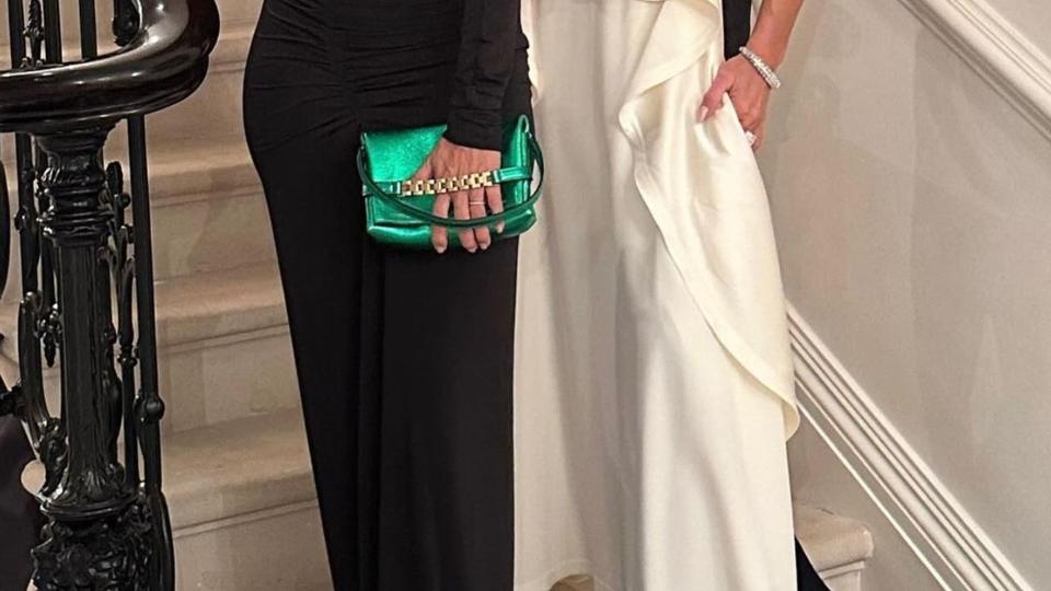 Victoria Beckham and Eva Longoria pose on a stair case. VB wear a white and black gown where Eva dons a black gown with a chest cutout