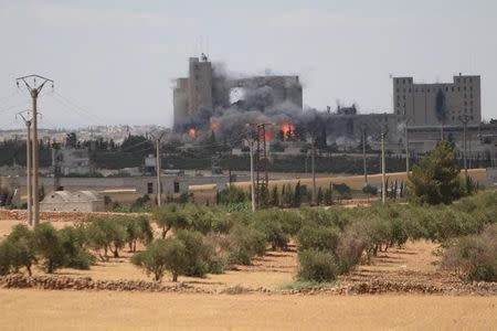 Smoke and flame rise after what fighters of the Syria Democratic Forces (SDF) said were U.S.-led air strikes on the mills of Manbij where Islamic State militants are positioned, in Aleppo Governorate, Syria June 16, 2016. REUTERS/Rodi Said