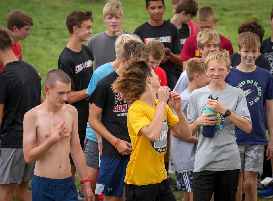 ADM runner Brycen Timmer, left, warms up prior to practice on Sept. 16. Timmer, who has autism, is in his first season running for the high school.