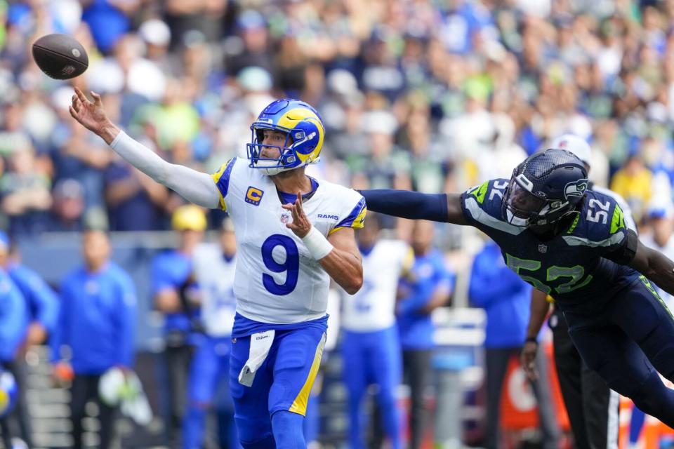 Rams quarterback Matthew Stafford passes under pressure from Seattle linebacker Darrell Taylor.