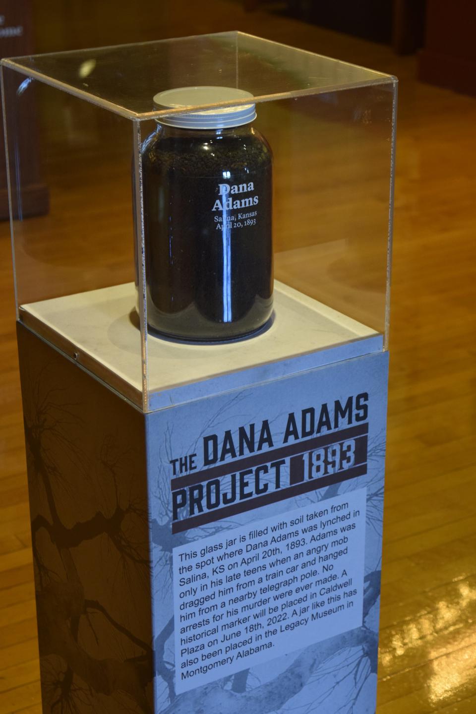 A glass jar of soil is on display at the Smoky Hill Museum. The soil was taken from the location of the lynching of Dana Adams in 1893.
