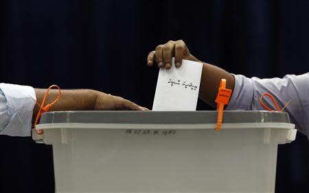 A man casts his vote at a polling centre during the presidential elections in Male September 7, 2013. REUTERS/Dinuka Liyanawatte