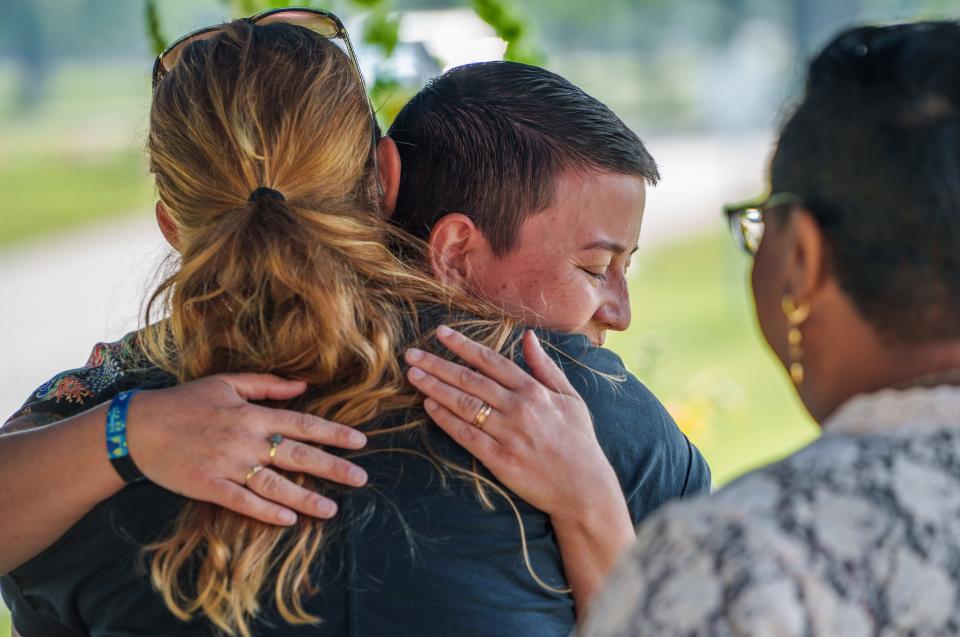 Elliot Zans (middle), with the Coalition for Homelessness Intervention and Prevention, gets a hug Thursday, June 8, 2023, from Tiffany Walls, with Tear Down The Walls Ministry, after a burial service for 75 people who died in Marion County but were never claimed from 2020 to 2021. "I knew a couple of the gentlemen we laid to rest today," Zans said. "I think it's wonderful and it's what our clients deserve. I think it's critically important. It was really powerful, poignant and I feel a lot of tenderness in this time in history when marginalized folks are put in such scary positions. Every breath we take feels very important. This feels really good to see some acknowledgment that these folks were here, they mattered and they should be laid to rest and not eternally in limbo on a shelf."