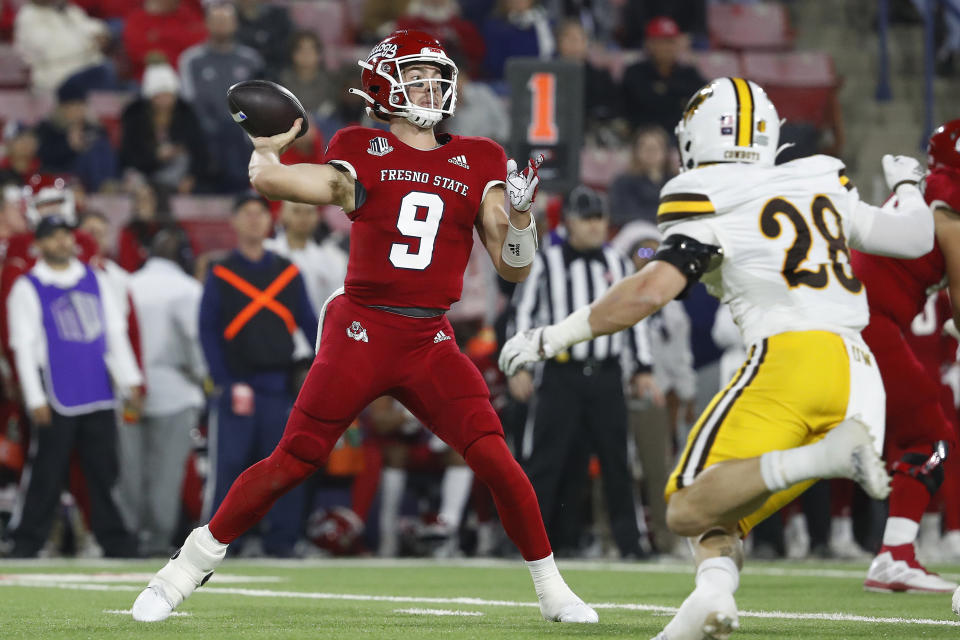 Fresno State quarterback Jake Haener drops back to pass as Wyoming linebacker Easton Gibbs chases him during the first half of an NCAA college football game in Fresno, Calif., Friday, Nov. 25, 2022. (AP Photo/Gary Kazanjian)