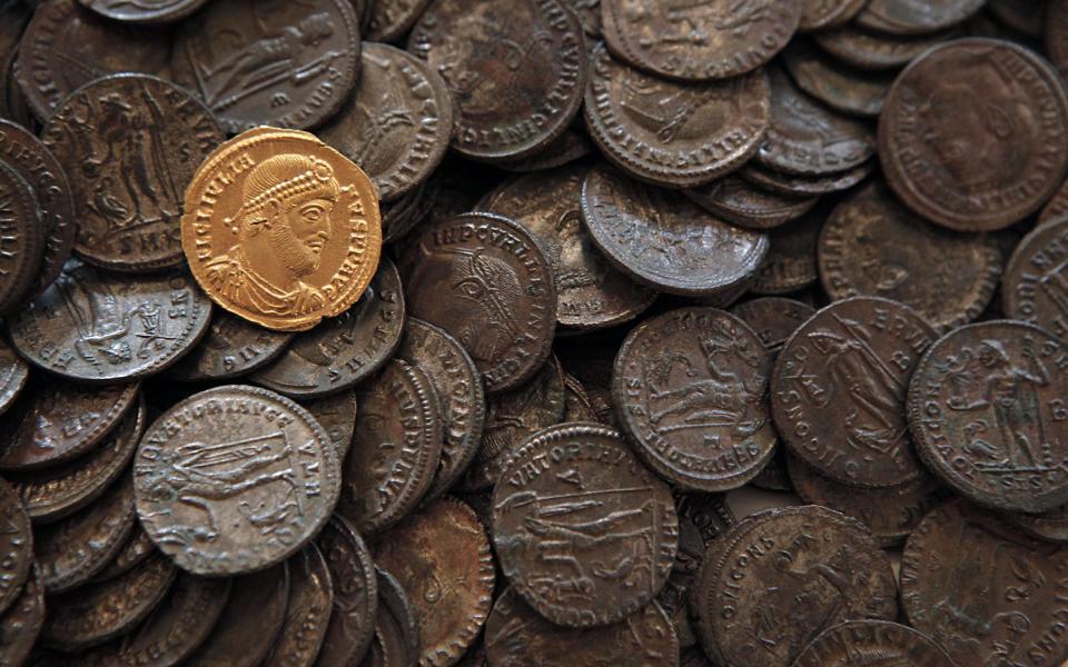 This Tuesday, Oct. 9, 2012 photo shows golden coin depicting the portrait of Roman emperor Julian the Apostate (who reigned between 361 and 363 CE) and other bronze coins from the same period, part of some 5,000 Roman items put at disposal at the National History Museum in Sofia,Bulgaria. Located on the crossroads of many ancient civilizations, Bulgarian scholars rank their country behind only Italy and Greece in Europe for the numbers of antiquities lying in its soil. But Bulgaria has been powerless to prevent the rape of its ancient sites, depriving the world of part of its cultural legacy and also costing this impoverished Balkan nation much-needed tourism revenue. (AP Photo/Valentina Petrova)