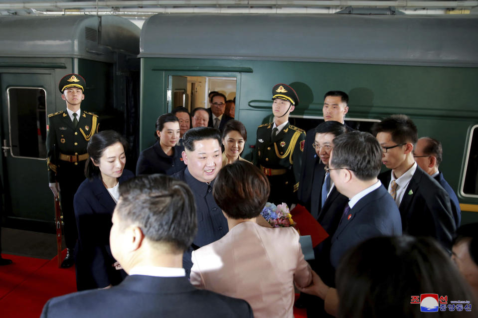 FILE - In this photo provided by the North Korean government, North Korean leader Kim Jong Un, center, and his wife Ri Sol Ju, center right, are greeted by Chinese Communist Party members on the arrival at Beijing station in Beijing, on March 26, 2018. The content of this image is as provided and cannot be independently verified. Korean language watermark on image as provided by source reads: "KCNA" which is the abbreviation for Korean Central News Agency. (Korean Central News Agency/Korea News Service via AP, File)