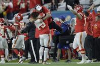 Kansas City Chiefs' Cameron Erving, gives a coach a lift on the sideline during the second half of the NFL Super Bowl 54 football game against the San Francisco 49ers Sunday, Feb. 2, 2020, in Miami Gardens, Fla. (AP Photo/John Bazemore)