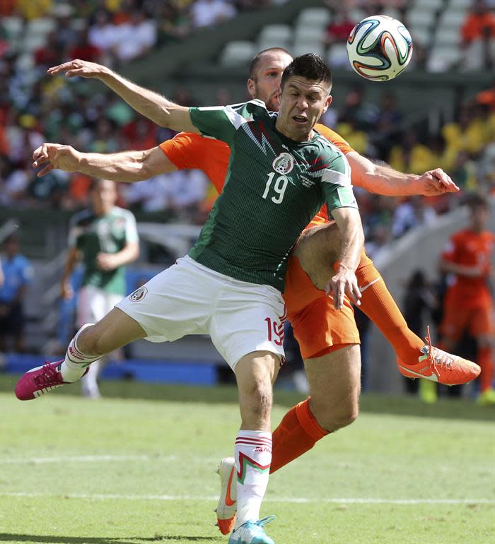 Oribe Peralta (d) lucha un balón ante el defensa holandés Ron Vlaar (detrás), durante el partido Holanda-México. (Foto: EFE/Mauricio Dueñas)