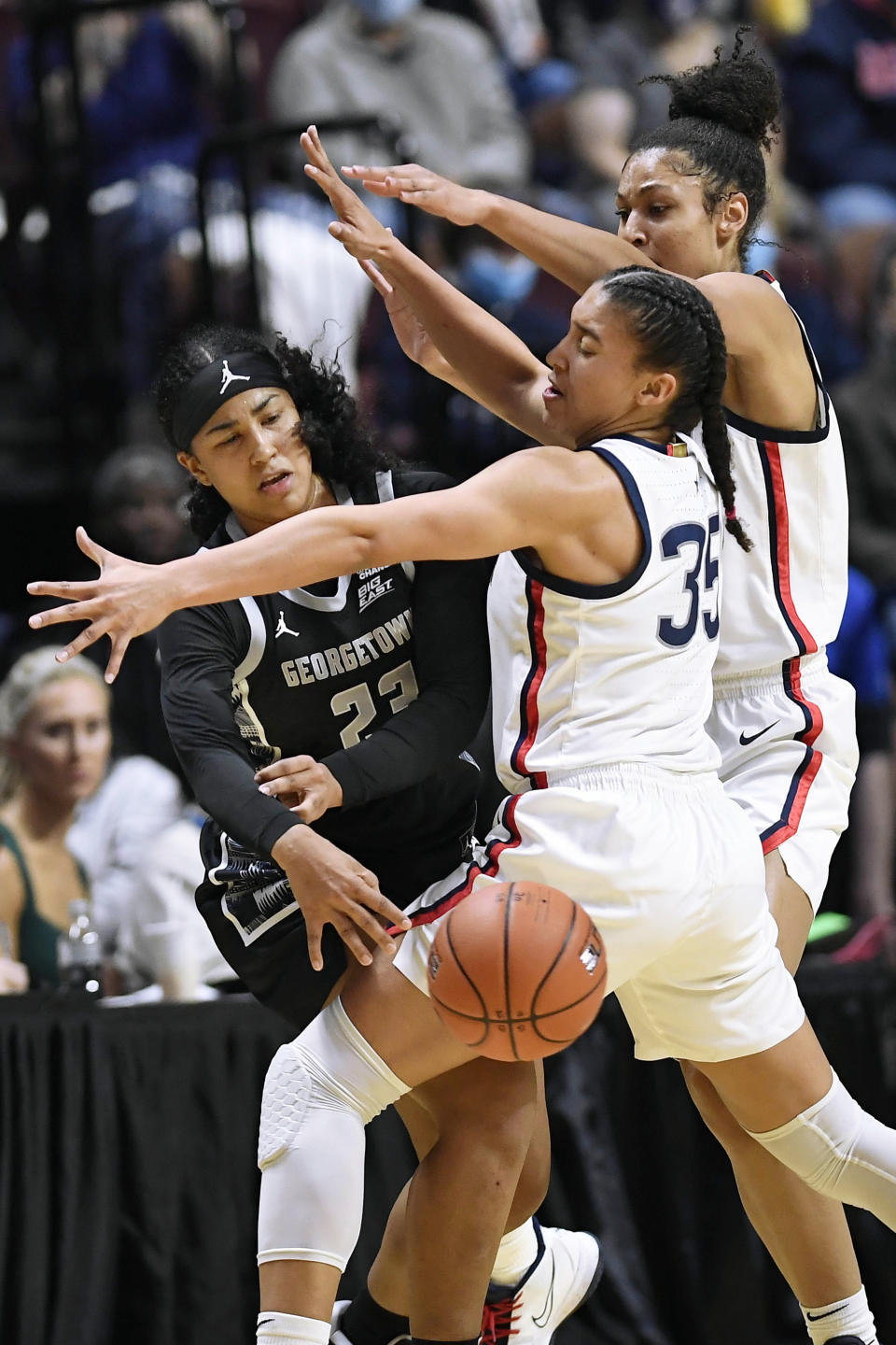 Georgetown's Milan Bolden-Morris (23) passes around Connecticut's Azzi Fudd (35) and Olivia Nelson-Ododa in the first half of an NCAA college basketball game in the Big East tournament quarterfinals at Mohegan Sun Arena, Saturday, March 5, 2022, in Uncasville, Conn. (AP Photo/Jessica Hill)