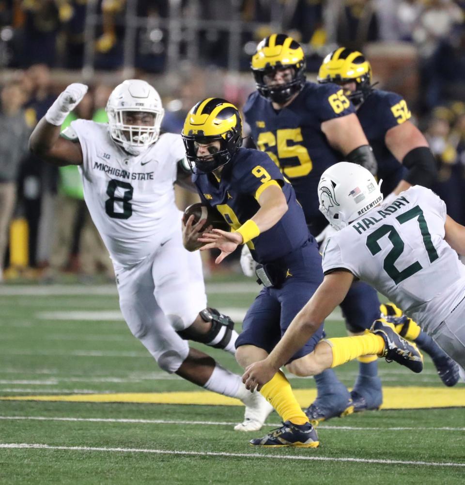 Michigan quarterback J.J. McCarthy runs by Michigan State defenders during the first half of Michigan's 29-7 win over Michigan State on Saturday, Oct. 29, 2022, in Ann Arbor.