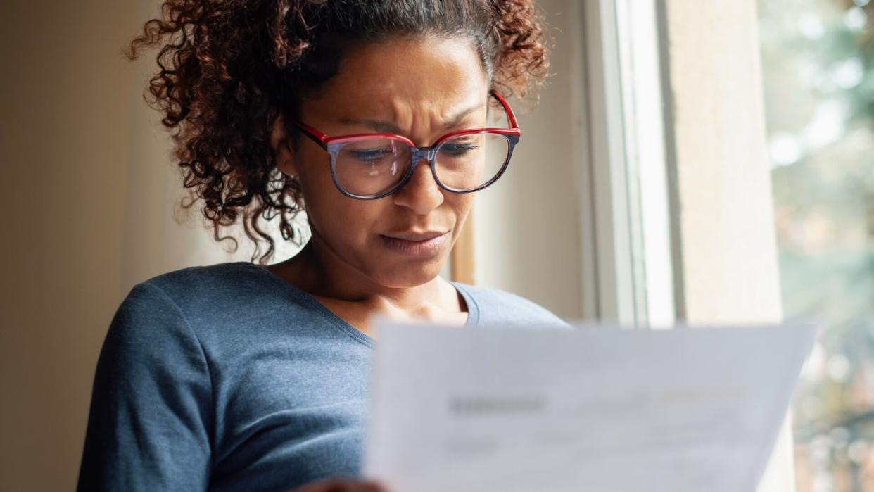 Portrait of worried black woman standing beside window.