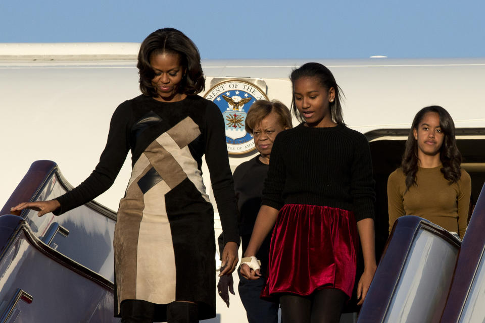 U.S. First Lady Michelle Obama, front left, her daughters Sasha, front right, Malia, right in the back, and Michelle Obama's mother Marian Robinson, left in the back, arrive at Capital International Airport in Beijing, China, Thursday, March 20, 2014. Michelle Obama has arrived in Beijing with her mother and daughters to kick off a seven-day, three-city tour where she will focus on education and cultural exchange. (AP Photo/Alexander F. Yuan, Pool)