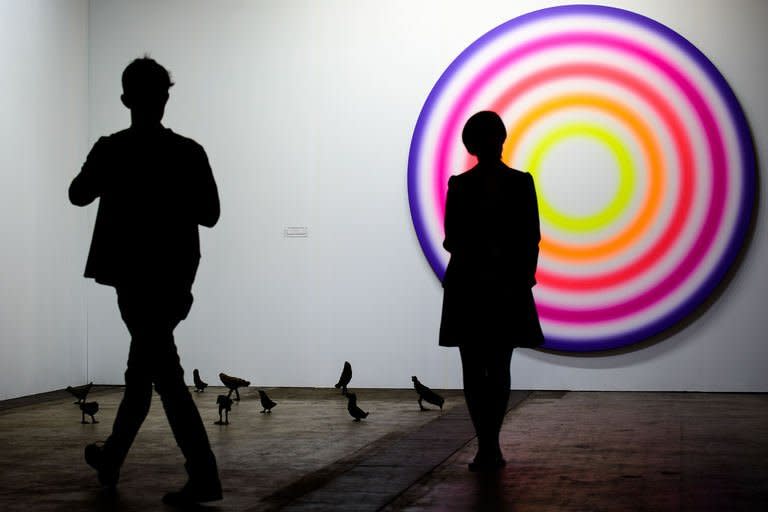 A man (L) and a woman look at a piece at the Art Basel Hong Kong fair in Hong Kong on May 22, 2013. The first Art Basel fair to be hosted by Hong Kong boasts a prestigious array of international art, highlighting the city's new role as a global arts hub amid an explosion of personal wealth in mainland China