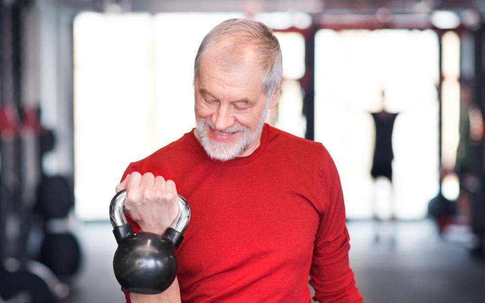 Senior man exercising with kettlebell in gym - Westend61/Getty Images