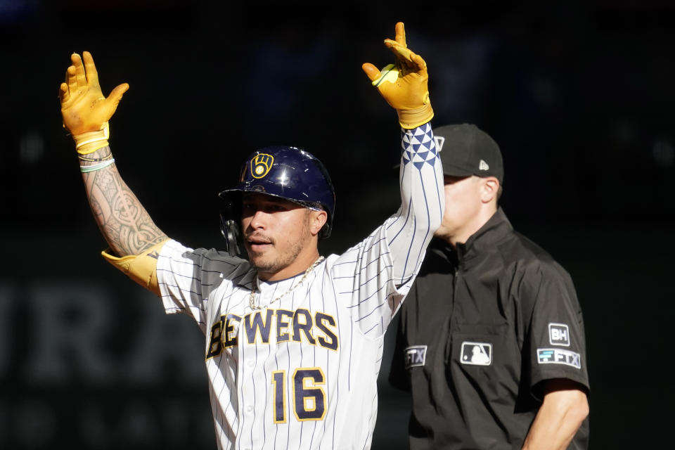 Milwaukee Brewers' Kolten Wong gestures after hitting an RBI-double during the ninth inning of a baseball game against the Miami Marlins, Sunday, Oct. 2, 2022, in Milwaukee. (AP Photo/Aaron Gash)