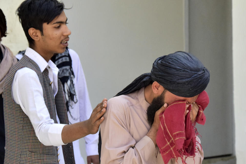 A man comforts to another mourning for his relative, who was killed in a bomb explosion, at a hospital, in Quetta, Pakistan, Friday, Sept. 29, 2023. A powerful bomb exploded at a rally celebrating the birthday of Islam's Prophet Muhammad in southwest Pakistan on Friday, killing multiple people and wounding dozens of others, police and a government official said. (AP Photo/Arshad Butt)