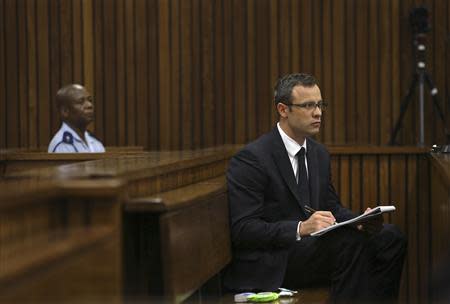 Olympic and Paralympic track star Oscar Pistorius takes notes during court proceedings at the North Gauteng High Court in Pretoria March 13, 2014. REUTERS/Themba Hadebe/Pool