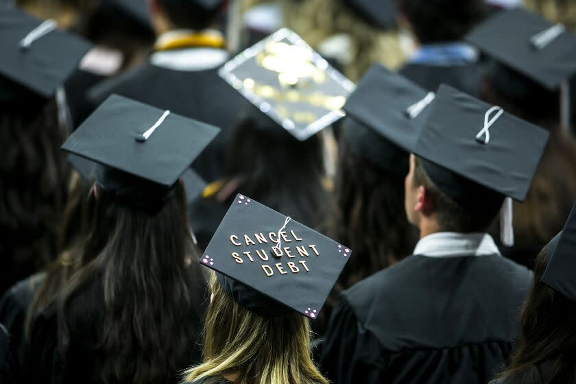 FILE - The cap of a University of Iowa graduates candidate is decorated with writing reading &quot;Cancel student debt&quot; during a commencement ceremony for the College of Liberal Arts and Sciences, Saturday, May 14, 2022, at Carver-Hawkeye Arena in Iowa City, Iowa. Massive tech layoffs, bank failures and a potential U.S. recession could throw a wrench in the plans of 2023 graduates &#x002014; in the same year federal student loan payments are expected to resume and accrue interest. (Joseph Cress/Iowa City Press-Citizen via AP, File)