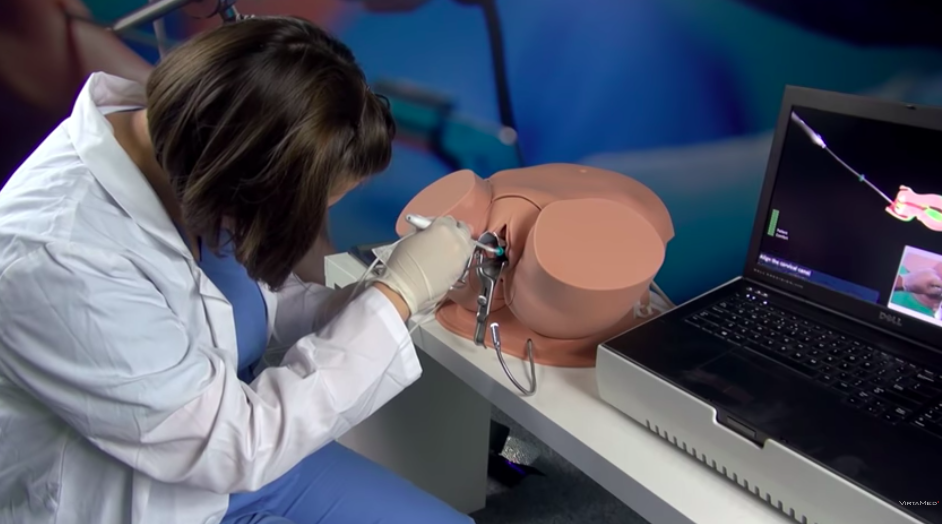 Una estudiante inserta un dispositivo intrauterino en una pelvis robótica diseñada para el entrenamiento médico. (Captura de pantalla VirtaMed)