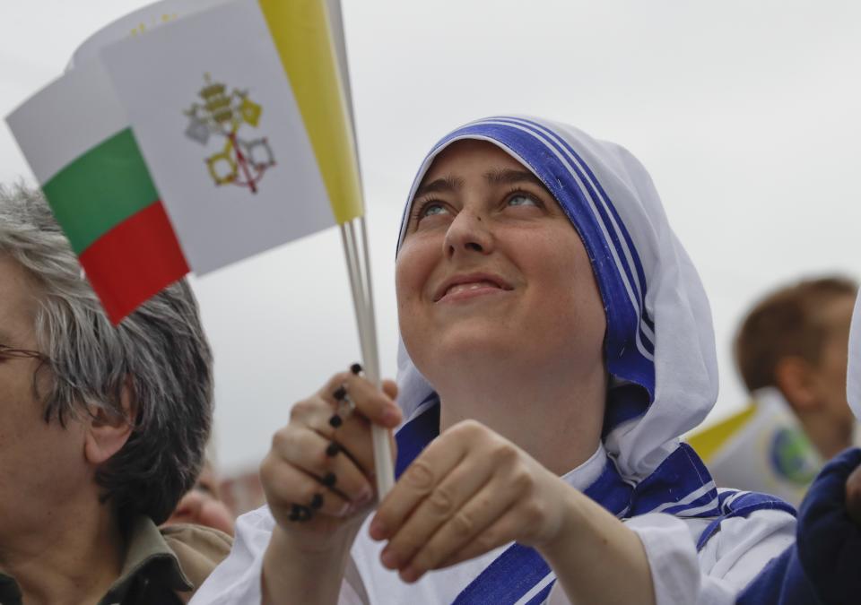 A nun holding the Vatican and Bulgarian flags looks up as she waits for Pope Francis in Alexander Nevsky square in Sofia, Sunday, May 5, 2019. Pope Francis is visiting Bulgaria, the European Union's poorest country and one that has taken a hard line against migrants, a stance that conflicts with the pontiff's view that reaching out to vulnerable people is a moral imperative. (AP Photo/ Alessandra Tarantino)