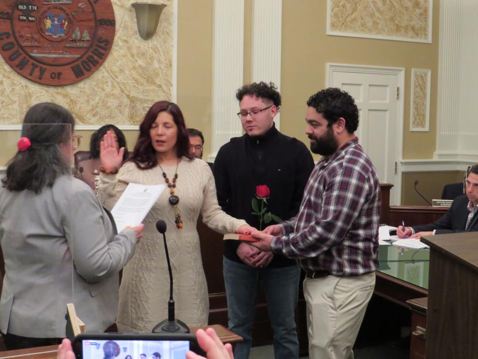 Karol Ruiz is sworn in as a Third Ward alderwoman at Dover Town Hall during the Board of Aldermen's 2023 reorganization meeting.  Holding the Bible is her husband, Brian Lozano.