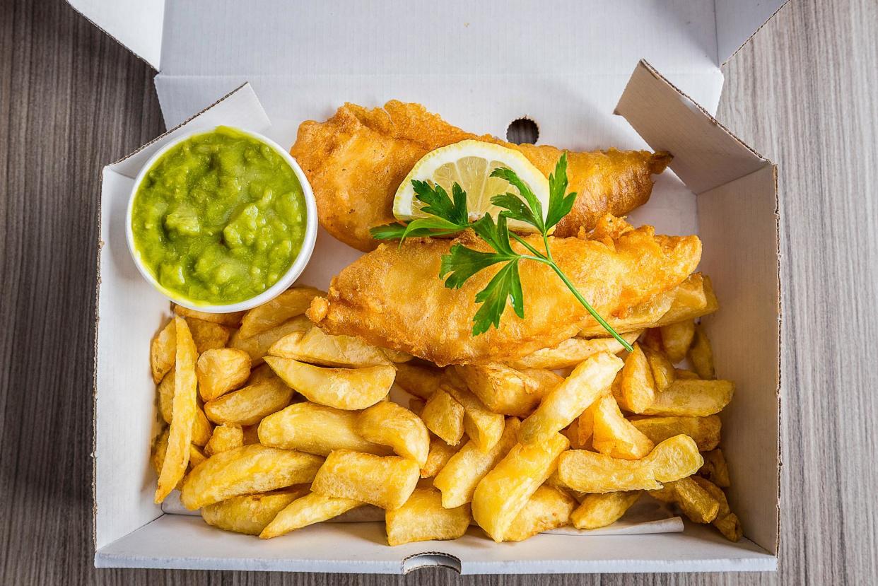 Fish and chips with peas and slice of lemon and garnish: iStock