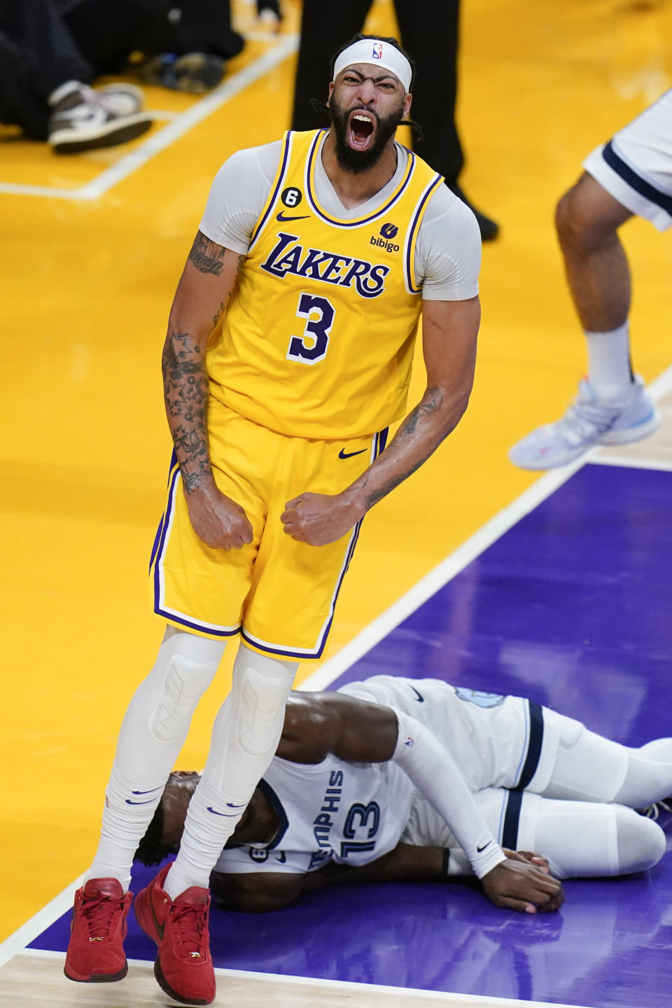 Los Angeles Lakers' Anthony Davis celebrates his dunk as Memphis Grizzlies' Jaren Jackson Jr. falls to the court during the second half in Game 6 of a first-round NBA basketball playoff series Friday, April 28, 2023, in Los Angeles. (AP Photo/Jae C. Hong)