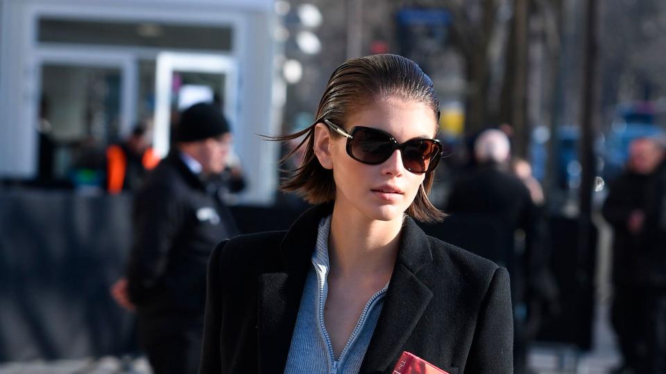 kaia gerber carrying a book at fashion week