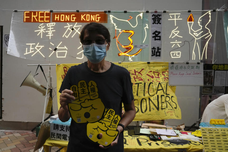 An activist delivers placards to people near the Hong Kong's Victoria Park Friday, June 4, 2021. Police arrested an organizer of Hong Kong's annual candlelight vigil remembering the deadly Tiananmen Square crackdown and warned people not to attend the banned event Friday as authorities mute China's last pro-democracy voices. In past years, tens of thousands of people gathered in Hong Kong's Victoria Park to honor those who died when China’s military put down student-led pro-democracy protests on June 4, 1989. Hundreds, if not thousands were killed. (AP Photo/Kin Cheung)