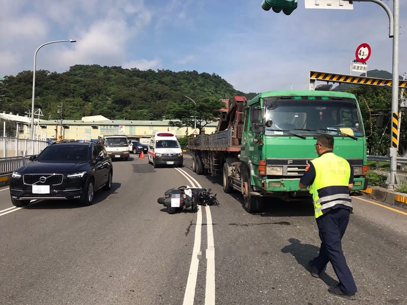 關渡大橋八里端下橋匝道18日上午發生機車和大貨車的車禍，機車騎士遭輾斃，肇事責任仍待警方調查釐清。（翻攝畫面） 