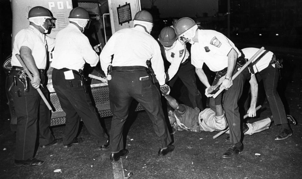 Boston Police officers wearing riot helmets and carrying batons arrest rioters in Roxbury on June 1, 1967. (Bob Dean/The Boston Globe via Getty Images)