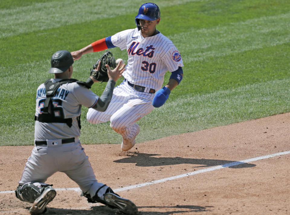 Miami Marlins catcher Ryan Lavarnway, left, prepares to tag out New York Mets' Michael Conforto (30) at the plate during the fifth inning of a baseball game at Citi Field, Sunday, Aug. 9, 2020, in New York. (AP Photo/Kathy Willens)