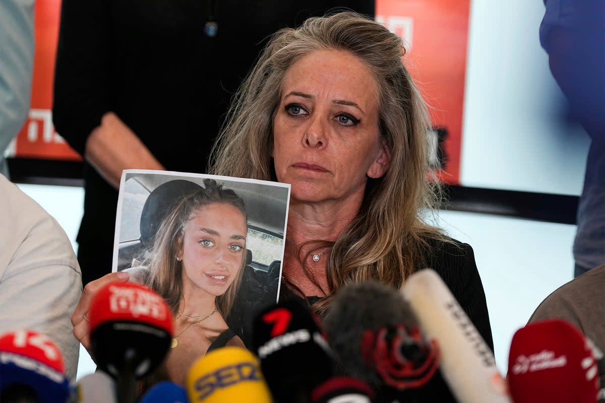 Keren Schem holds a photograph of her 21-year-old daughter, Mia Schem, who is currently being held hostage by Hamas  (AP)