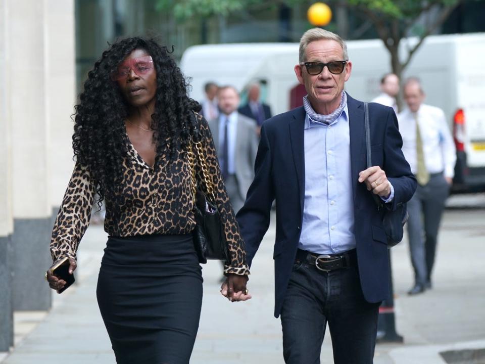 Paul Cook arrives at the Rolls Building at the High Court in London with his wife Jeni (Yui Mok/PA) (PA Wire)