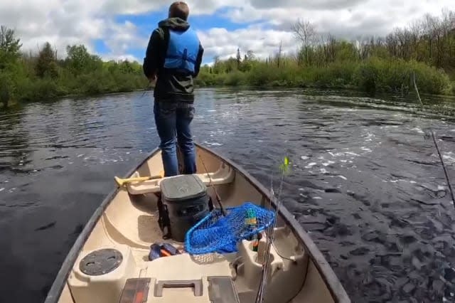 Men in boat fall into water while trying to catch a big fish