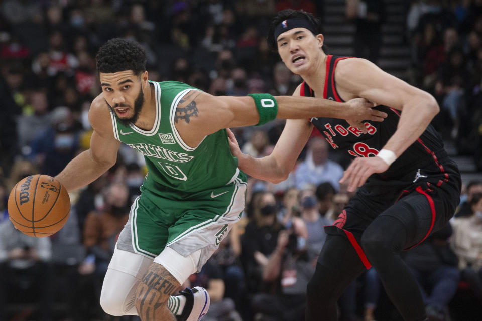 Boston Celtics' Jayson Tatum (0) drives past Toronto Raptors' Yuta Watanabe during the first half of an NBA basketball game in Toronto, Sunday, Nov. 28, 2021. (Chris Young/The Canadian Press via AP)