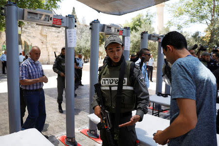 An Israeli border police officer asks to check the identity of a Palestinian man next to newly installed metal detectors at an entrance to the compound known to Muslims as Noble Sanctuary and to Jews as Temple Mount to be reopened, in Jerusalem's Old City July 16, 2017. REUTERS/Ronen Zvulun