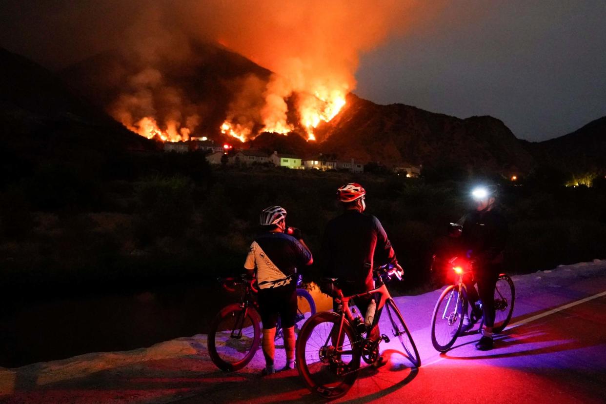 Cyclists rest along a trail as the Ranch Fire burns, Thursday, Aug. 13, 2020, in Azusa, California: AP