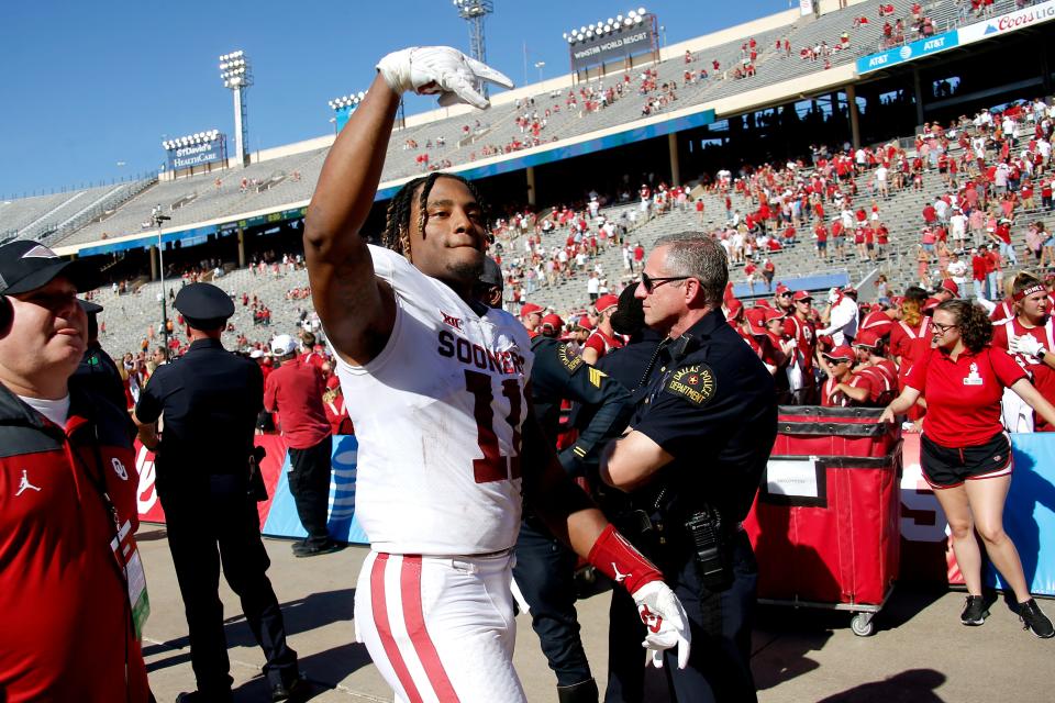 Nik Bonitto (11) gives the Horns Down gesture after OU's 55-48 win against Texas on Oct. 9 at the Cotton Bowl in Dallas.