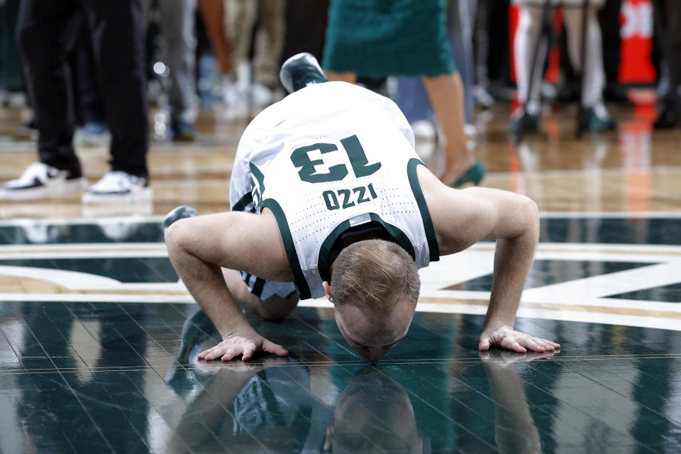 Michigan State senior Steven Izzo kisses the court following an NCAA college basketball game against Northwestern, Wednesday, March 6, 2024, in East Lansing, Mich. Michigan State won 53-49. (AP Photo/Al Goldis)