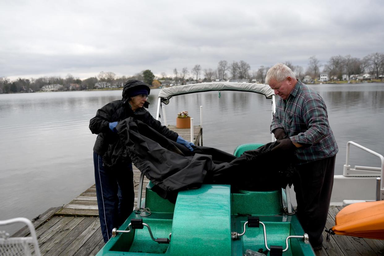 Tracy Stadelman, with help from family friend Danny Fehn,  removes her paddle boat from water as she prepares for winter at her Meyers Lake home. Friday, December 16, 2022.