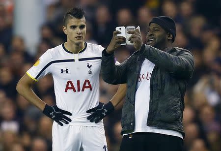 A spectator runs onto the pitch and takes a 'selfie' of himself and Tottenham Hotspur's Erik Lamela (L) during their Europa League soccer match against Partizan Belgrade at White Hart Lane in London November 27, 2014. REUTERS/Eddie Keogh